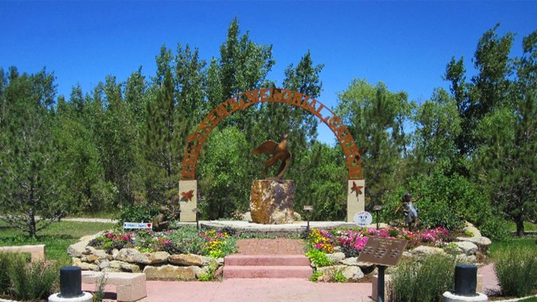 Stairs leading up to an arch surrounded by blooming flowers at McManamen Park in Gillette, Wyoming.