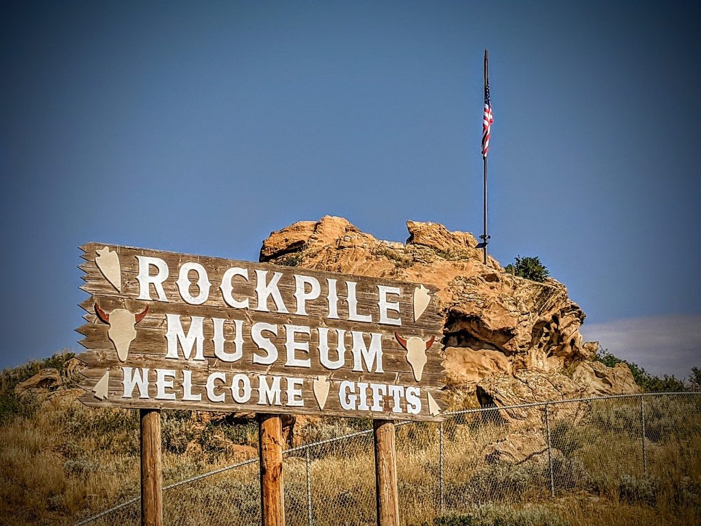 The rustic sign of the Rockpile Museum under a cloudy sky invites visitors for a cultural journey, a top thing to do in Gillette, Wyoming.
